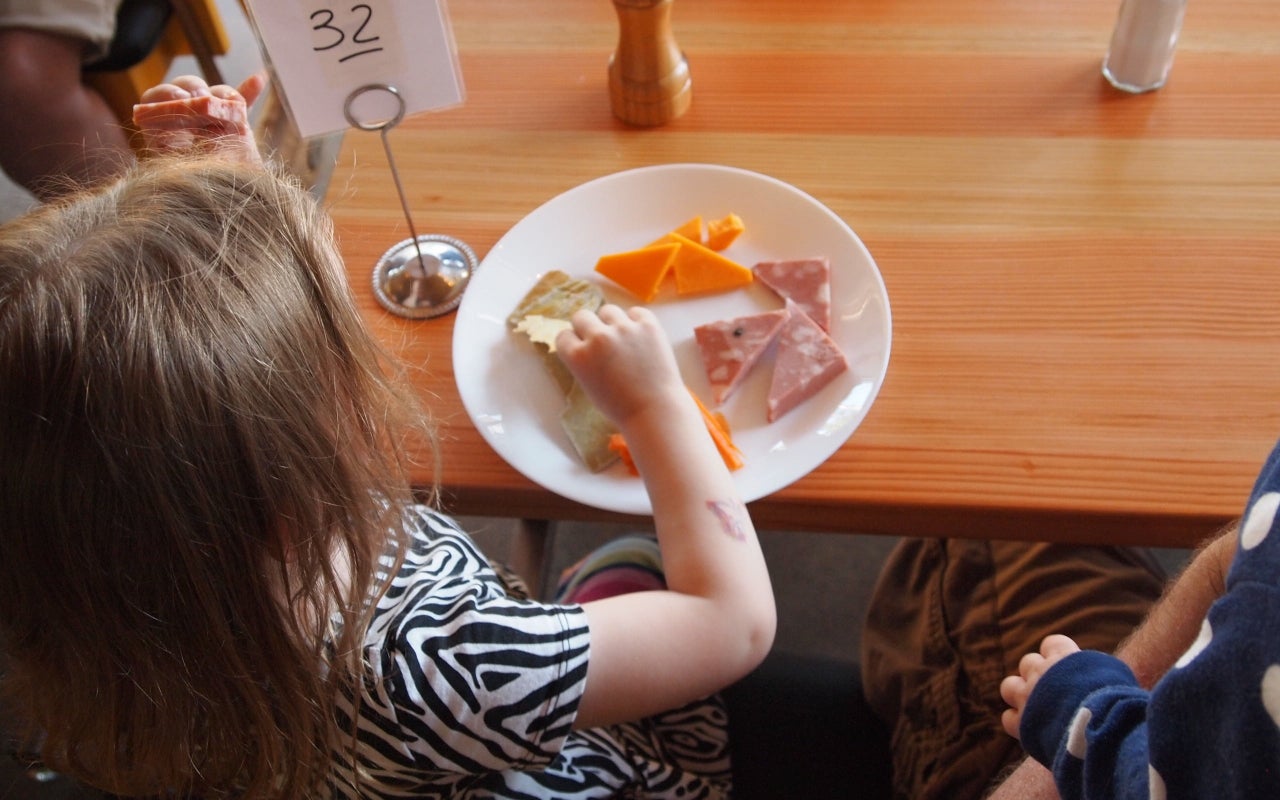 Una nena menjant en un restaurant | Pixabay