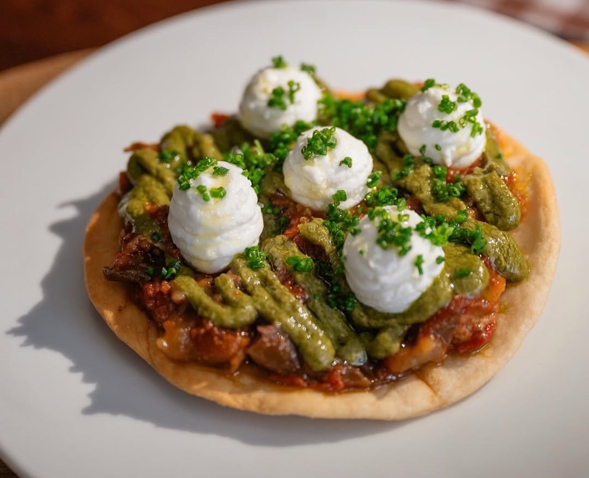 Coca cruixent amb albergínia, romesco verd de festucs i crema de formatge | Instagram @casanitarestaurant