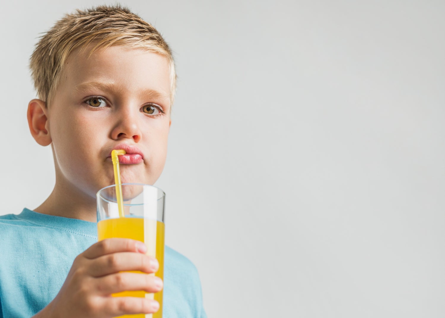 Un nen que beu un suc de fruita | Freepik